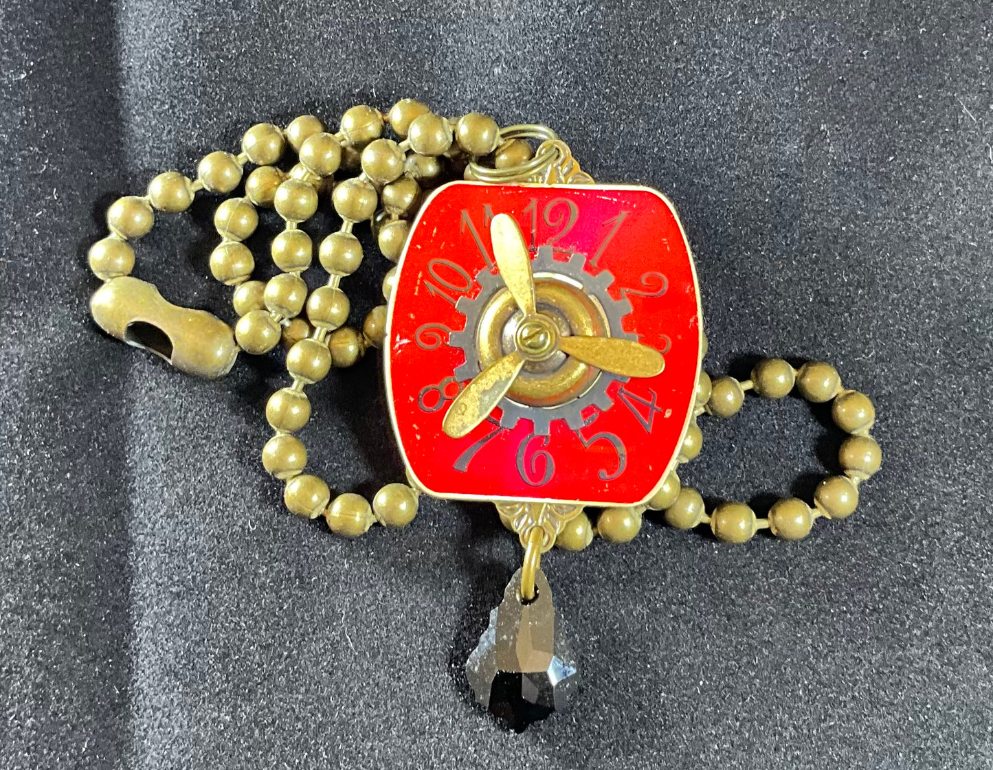 red watch face and propeller necklace