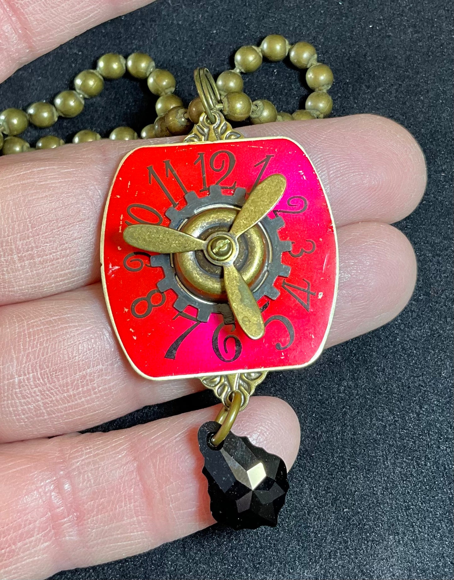 red watch face and propeller necklace