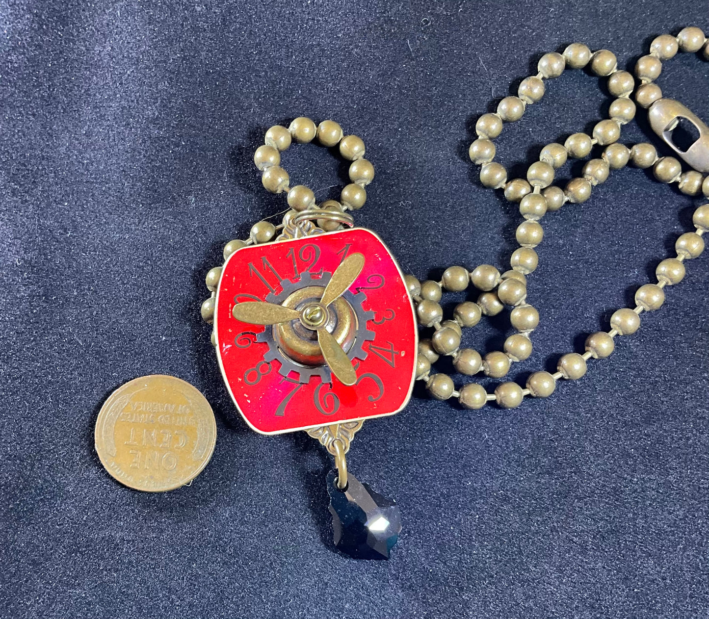 red watch face and propeller necklace