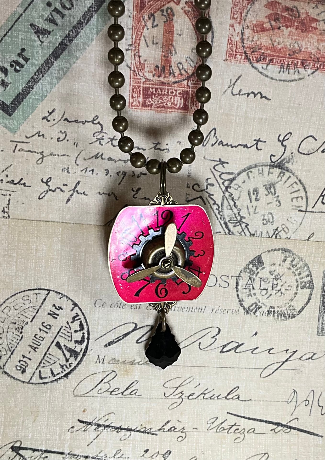 red watch face and propeller necklace